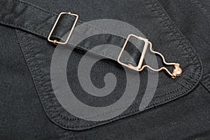 Closeup of a black denim with copper elements and seams