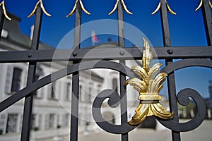 White palace and black fence with golden elements closeup