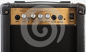 Closeup of a black and golden guitar amplifier with knobs