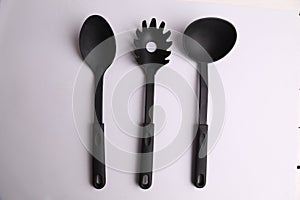 Closeup of black kitchen utensils on white background