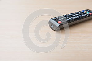 Closeup black remote control on the wood background