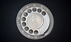 Closeup of black retro vintage telephone with rotary dialer or dial-pad.