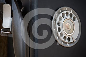 Closeup of black retro vintage telephone with rotary dialer or dial-pad.