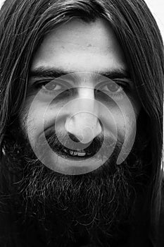 Closeup black-and-white portrait of a bearded man with long hair.