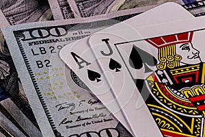 Closeup of a Blackjack 21 hand on a bed of one hundred dollar bills III
