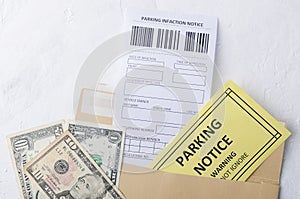 Closeup of blank parking violation notice, parking warning notice and cash for penalty in an envelope on the white table