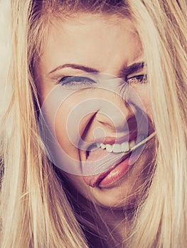 Closeup of blonde woman sticking tongue out
