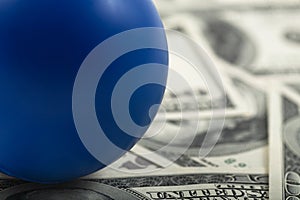 Closeup of blue ball on stack of cash