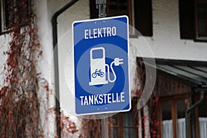 Closeup of a blue Elektro tankstelle - Electric gas station sign with a blurry background