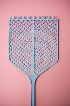 Blue fly swatter on pink background