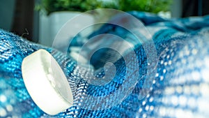 Closeup of a blue knitted texture with a white button