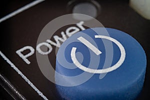 Closeup of a blue power button on TV remote
