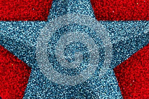 Closeup of a blue star on red glitter textured paper