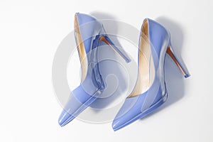 Closeup blue women patent leather shoes isolated on white background. Stilettos shoe type. Summer fashion and shopping concept.