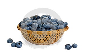 Closeup blueberry in wicker basket and small piles on white background