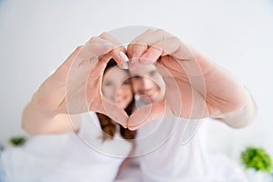 Closeup blurry focus photo of adorable lady handsome guy married couple together overjoyed hold hands making heart