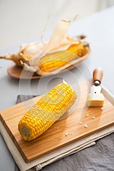 Closeup on boiled corn and butter on cutting board