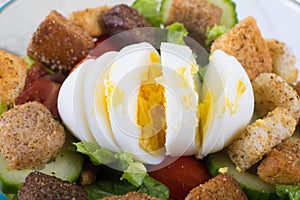 Closeup of boiled egg which was badly sliced on top of a salad