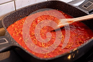 Closeup of boiling chopped tomatoes sauce in a pan