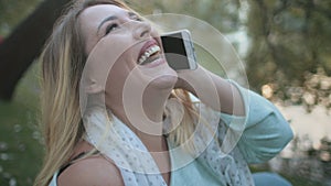 Closeup bokeh portrait of businesswoman using phone at river shore. Body positive girl speak mobile