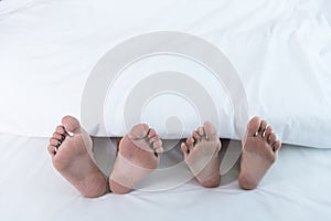 Closeup both feet couple lying