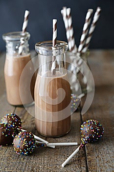 Closeup of bottles chocolate milk and cake pops