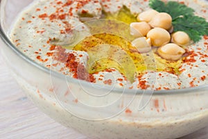 Closeup of A bowl of creamy hummus with olive oil.