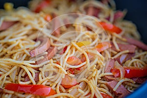 Closeup bowl of spicy spaghetti with sausages