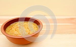 Closeup of bowl of vegetable soup on a wooden table