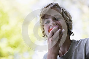 Closeup Of Boy Eating Apple Outdoors