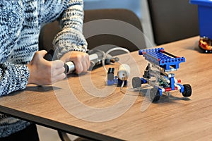 Closeup of boy`s hands pumping up the constructor and learning the basics of pneumatics at school. Robotics, STEM photo