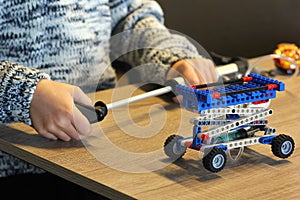 Closeup of boy`s hands pumping up the constructor and learning the basics of pneumatics at school. Robotics photo