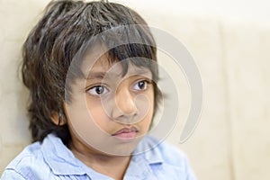 Closeup of boy or student in blue shirt staring at