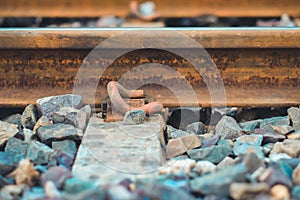 Closeup Bracket for railway tracks with concrete sleepers and rubble