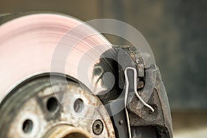 Closeup of braking disc of the vehicle with brake caliper for repair in process of new tire replacement. Car brake repairing in