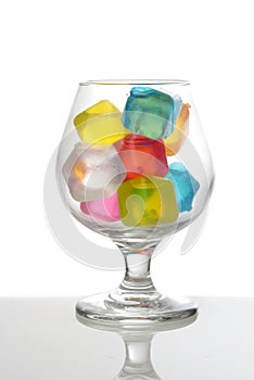 Closeup brandy glass with multi colored plastic ice cubes
