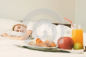 Closeup of breakfast in front of sleeping woman