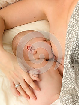 Closeup breastfeeding in bed