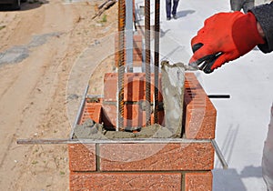 Closeup of a Bricklayer Worker Installing Red Blocks. Bricklaying.
