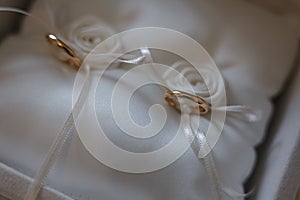 Closeup of bridal sterling golden rings in a special cushion for rings