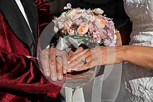 Closeup of bride and groom holding hands and showing rings on Wedding day, special occasion