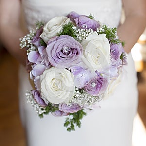 Closeup bride holding bouquet of pink roses