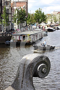 Closeup of bridge ornament closeup, boats on Amstel, Amsterdam