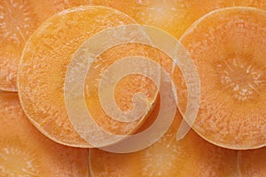 Closeup bright round carrot slices, Vegetable pieces background. Orange monochrome horizontal shot for creative desigh about