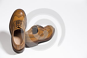 Closeup of Brogue Derby Shoes of Calf Leather with Rubber Sole Near One Another Over Pure White Background