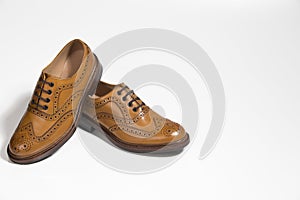 Closeup of Brogue Derby Shoes of Calf Leather with Rubber Sole On One Another Over Pure White Background