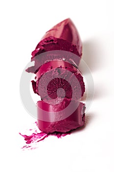 Closeup of broken beautiful purple lipstick. Fashion. Bright Background.