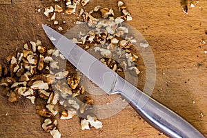 Closeup of broken, chopped walnuts on an old wooden kitchen boar
