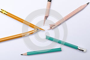 Top view of broken several pencils on the white paper.Concept of hard learning and stress photo