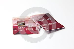 Closeup of the broken red credit card on the white background.